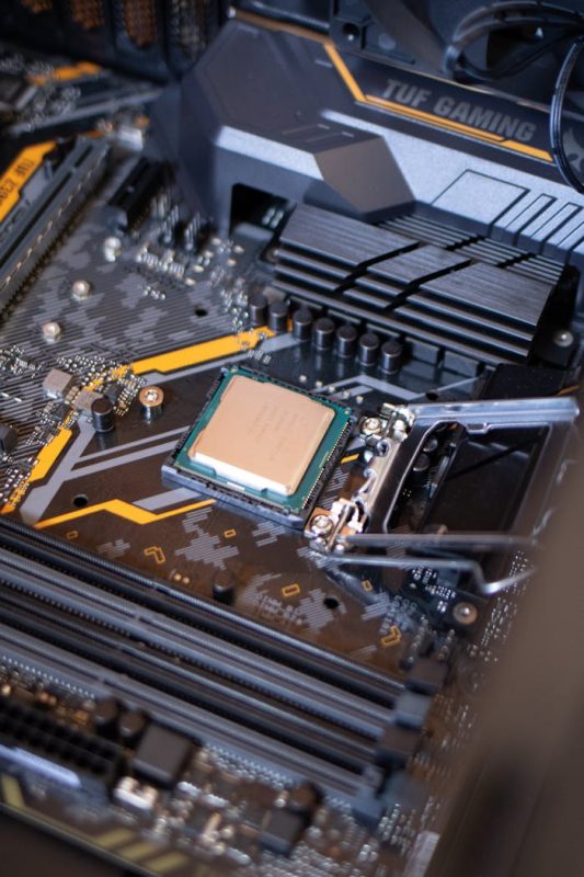pexels-photo-2582935 Detailed view of a motherboard with an exposed CPU, showcasing technology components.
